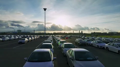 Backlit parked car rows beneath a low sun in Guangzhou China Stock Footage 345957407
