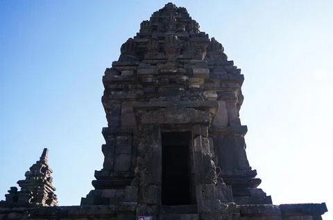 Backlit Prambanan Temple shrine forms a dramatic stone silhouette with a da.. Stock-Fotos