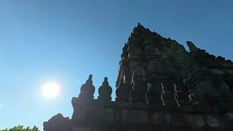 Backlit Prambanan Temple tower forms a dramatic silhouette beside the glowi.. Stock Footage 341542610
