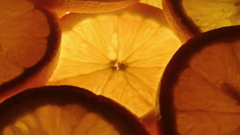 Backlit rotating citrus slices around center for fresh summer drink visuals Stock Footage 331260124