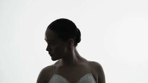 Backlit silhouette of a ballet dancer in contemplative profile during graceful 스톡 동영상 347243155