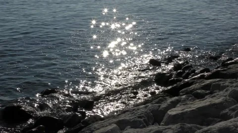 Backlit sparkling highlights ocean sea water rocks waves movement Stock Footage 57233618