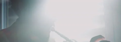 Backlit view of a trumpeter playing in his apartment Stock Footage 202309460