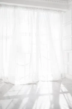 Backlit window with white curtains in empty room Stock Photos