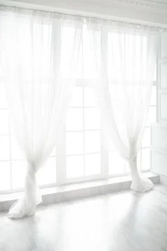 Backlit window with white curtains in empty room Stock Photos