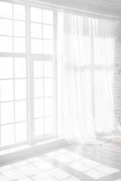 Backlit window with white curtains in empty room Stock Photos