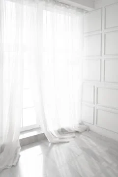 Backlit window with white curtains in empty room Foto stock
