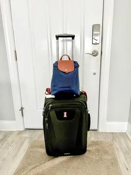 A backpack and a suitcase ready to go to the airport for a vacation Stock Photos