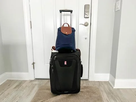 A backpack and a suitcase ready to go to the airport for a vacation Stock Photos