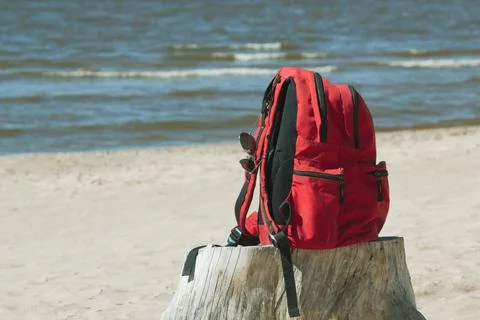 Backpack and sunglasses on the beach Stock Photos