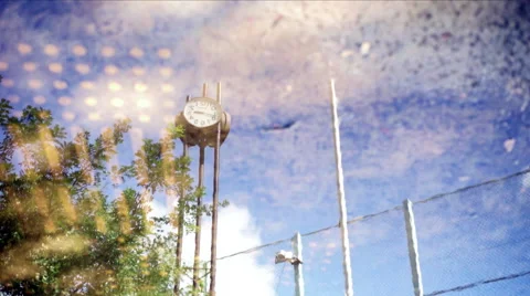 Backpack of the baseball stadium reflecting on the puddle and the clock of t Stock Footage 67626810
