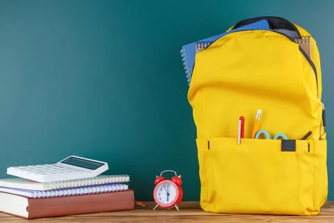 Backpack on the desk in the classroom. Stock Photos