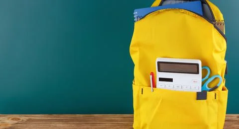 Backpack on the desk in the classroom. Stock Photos