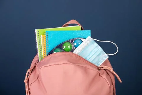 Backpack with different school stationery and medical mask. Coronavirus conce Foto stock