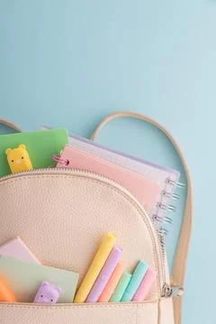 Backpack full of school supplies and colorful stationery Stock Photos