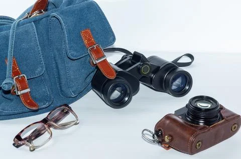 Backpack, glasses, binoculars, and camera - a hiking kit. Stock Photos