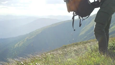 A backpack on the grass on a sunny day, a man picks it up and leaves Stock Footage 228732053