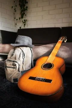 A backpack, a hat, and a guitar ready to travel Stock Photos
