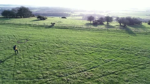 Backpack hiking man walking in field, winter in Pewsey, Wiltshire, England 스톡 동영상 235065480