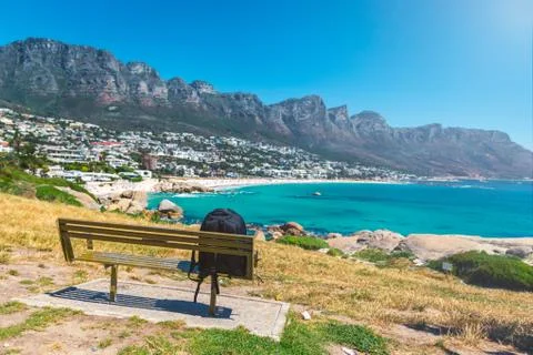 Backpack of lonely traveller on a bench with a view of Camps bay beautiful be Stock Photos