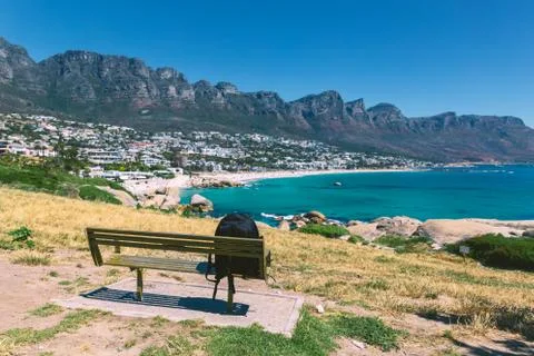 Backpack of lonely traveller on a bench with a view of Camps bay beautiful be Stock Photos