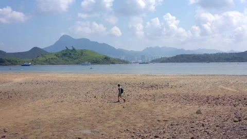 Backpack man walking on beach next to the sea, Ting Kok Delta, Tai Po, Hong K 스톡 동영상 163319206