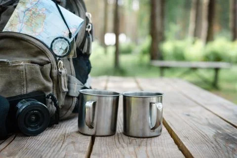 Backpack with maps and two mugs. Stock Photos