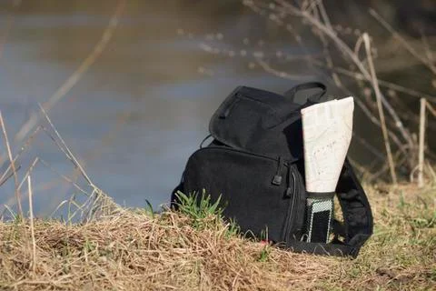 Backpack with phone and map in the pocket on the shore Stock Photos