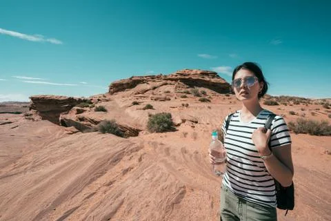 Backpack relaxing under the sun making up water 库存照片