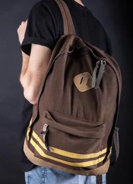Backpack on the shoulder of a young man Stock Photos