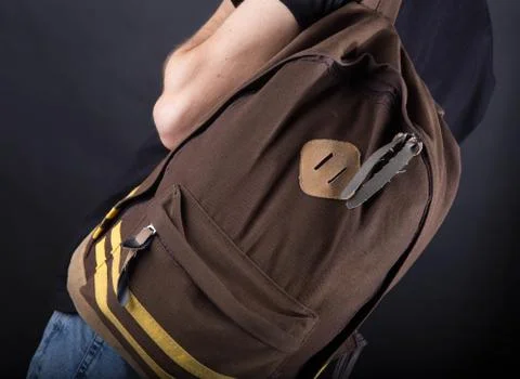 Backpack on the shoulder of a young man = Stock Photos