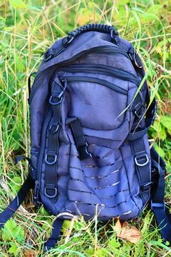 A backpack sitting in the grass on the ground Stock Photos