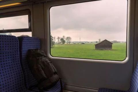Backpack on train seats and a landscape window view Stock Photos