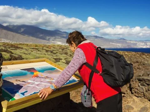 Backpacker with backpack is looking at an information board on Tenerife Stock Photos