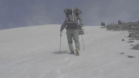Backpacker climbing up snow slope Stock Footage 166708668