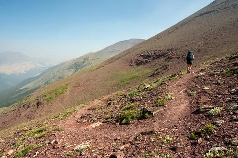 Backpacker Climbs The Red Gap Pass Trail In Glacier 库存照片