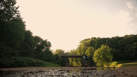 Backpacker Crossing Stream at Sunset with Bridge - New England Trail Stock Footage 346803310