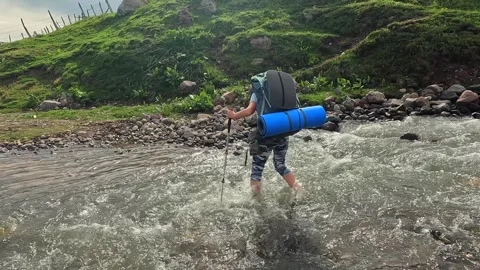 Backpacker crossing stream wide shot in rural Georgia Stock Footage 338426442