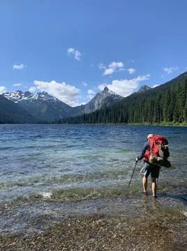 Backpacker dips sore feet in the cold water of Waptus Lake Stock Photos