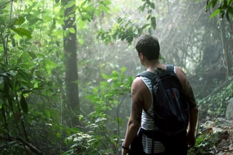 Backpacker finding his way through the tropical jungle of Van Vieng in Laos Stock Photos