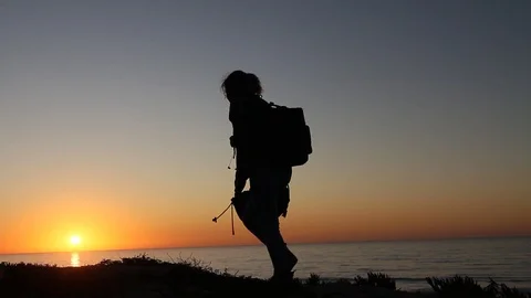 Backpacker gets to top of hill and takes a break Stock Footage 123200944