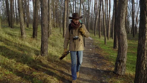 A backpacker with a guitar and a camera walks along a trail in the forest Stock Footage 144177140