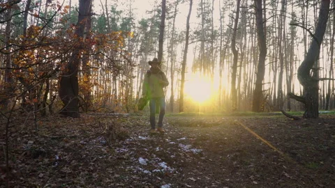 A backpacker with a guitar and a camera walks along in the forest Stock Footage 146323801