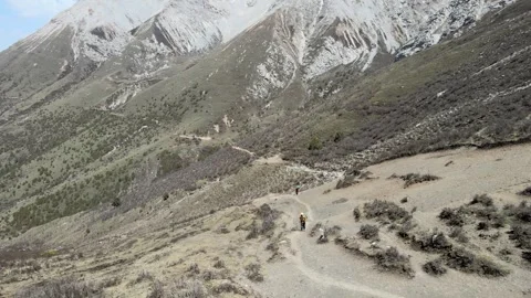 Backpacker hiking a rugged mountain trail in Zhagana with towering rocky peaks Stock-Footage 347679538