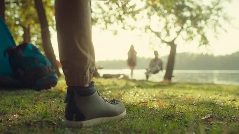 Backpacker joining his friends in camping. Bonfire and lake on the background Stock Footage 96240212
