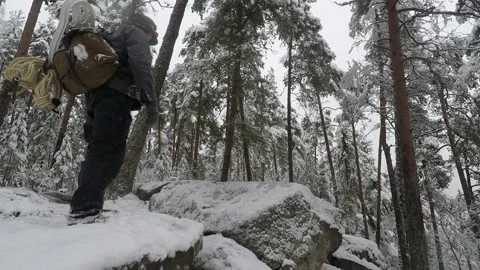 Backpacker jumping along icy rocks Stock Footage 145953606