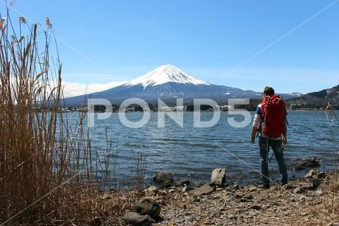 Backpacker looking at Mount Fuji from lake Kawaguchi in Japan Stock Photos
