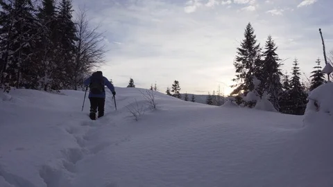 Backpacker man going through deep snow at sunset. Stock Footage 101511130