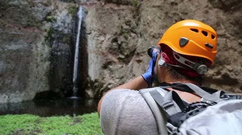 Backpacker man hiking and taking pictures of waterfall in Barranco del Infier Stock Footage 68856458