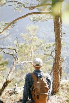 Backpacker man resting near the tree. Stock Photos